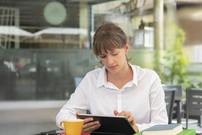 Young woman using mobile phone in cafe