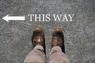 Low section of man standing on road