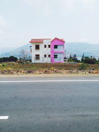 Building by road against sky