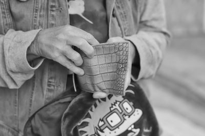 Midsection of man holding wallet while standing outdoors