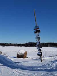 View of snow covered field against clear blue sky