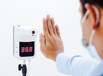 Midsection of man using smart phone against white background