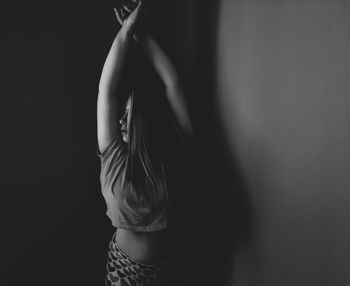 Close-up of woman standing against black background