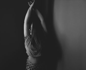 Close-up of woman standing against black background