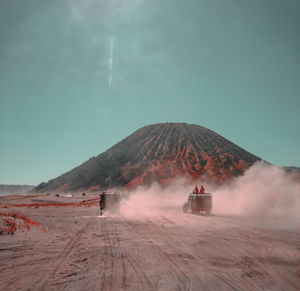 View of a car on a desert at lautan pasir bromo mountain