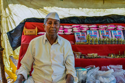 Portrait of man standing at market stall