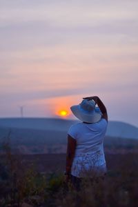 Man looking at sea against sky during sunset