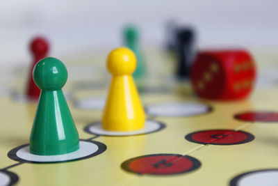 Close-up of game pieces and dice on ludo