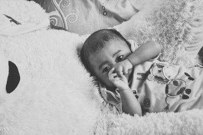 High angle portrait of cute baby boy lying on bed at home