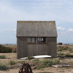 Old abandoned building on field against sky