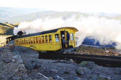 Train on railroad track against sky during winter