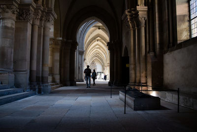 Rear view of person walking in corridor of building