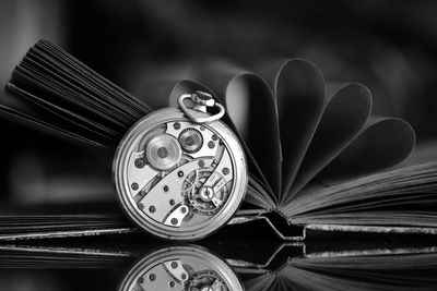 Close-up of pocket watch and book on table