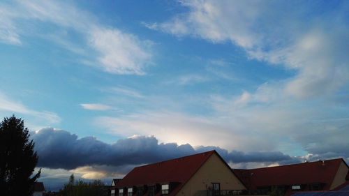 Low angle view of houses against cloudy sky