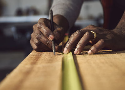 Cropped hands of carpenter working at workshop