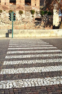 Cobblestone street by old building in city