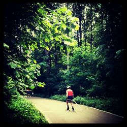 Rear view of woman walking on road