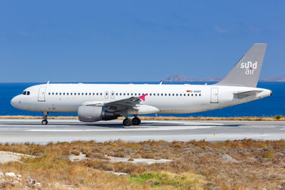 Airplane on airport runway against clear sky