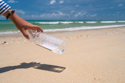 Close-up of hand holding sand on beach