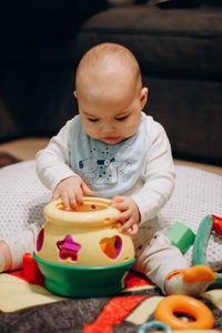 Portrait of cute baby boy playing with sorter toy at home