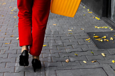 Low section of woman walking on sidewalk