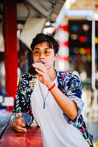 Young man drinking beer while looking away