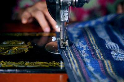 Cropped image of woman using sewing machine