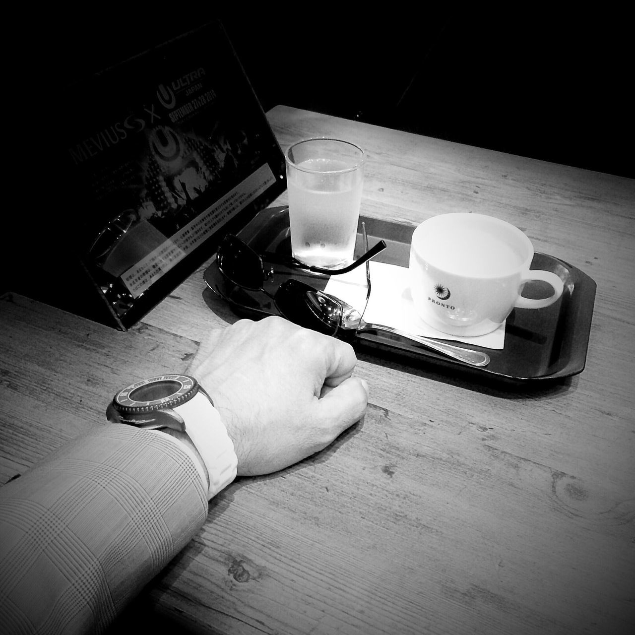 indoors, table, food and drink, drink, technology, still life, communication, coffee cup, holding, close-up, wireless technology, paper, refreshment, high angle view, wood - material, pen, book, person