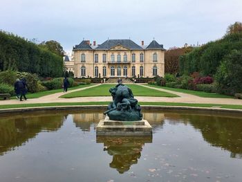 Statue by lake against building