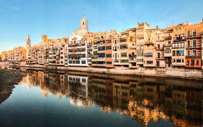 Reflection of buildings in river against sky