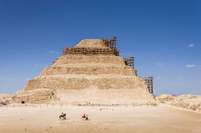 Tourists at historical building against sky