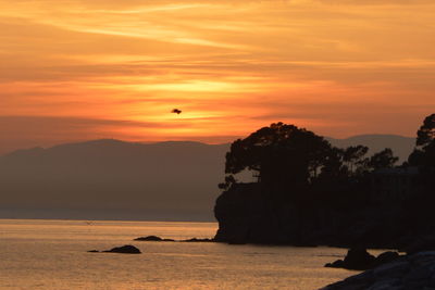 Scenic view of sea against orange sky
