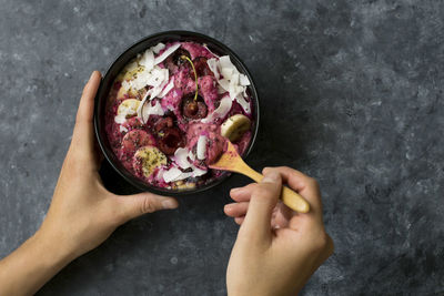 Cropped image of person holding bowl of ice cream with fresh fruits