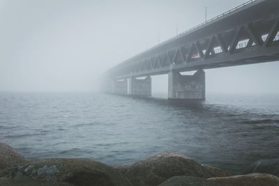 Bridge over sea in fog