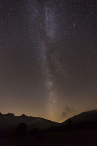 Low angle view of mountain against star field