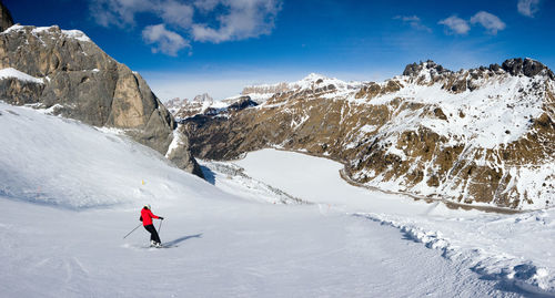 Man skiing on snowcapped mountain against sky