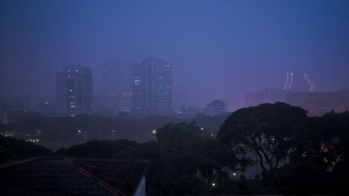 Illuminated cityscape against sky at night