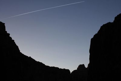 Low angle view of silhouette mountain against clear sky