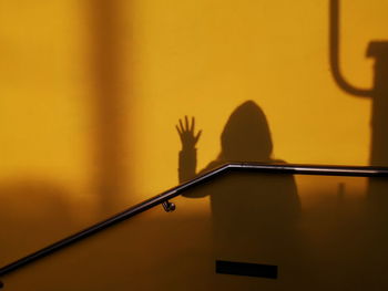 Shadow of person gesturing on wall
