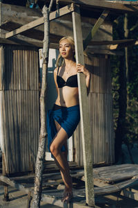 Seductive woman standing on wooden plank