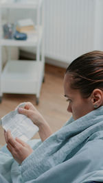 Side view of boy using digital tablet while sitting at home