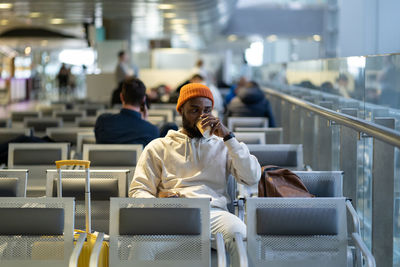 Man drinking coffee while waiting at airport