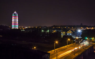 Illuminated porcelain tower of nanjing in city against sky at night