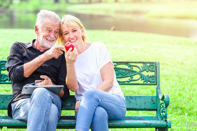 Portrait of a couple sitting on park bench