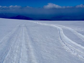 Snow covered landscape against sky