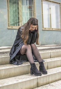 Young woman sitting on staircase