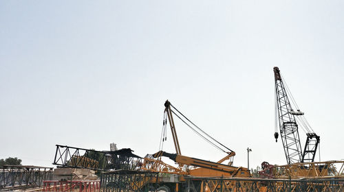 Low angle view of cranes against sky