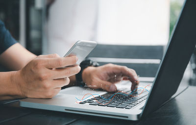 Midsection of woman using mobile phone on table