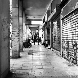 People walking on footpath amidst buildings in city