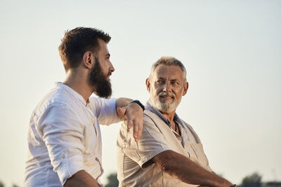 Father and adult son talking outdoors